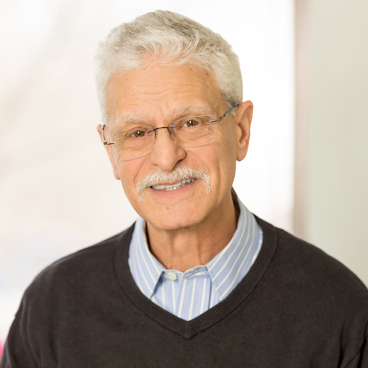 Softly lit close up of Dr. Alan Newton smiling.